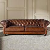 Chesterfield stílusú, háromszemélyes konyakbarna bőrkanapé.